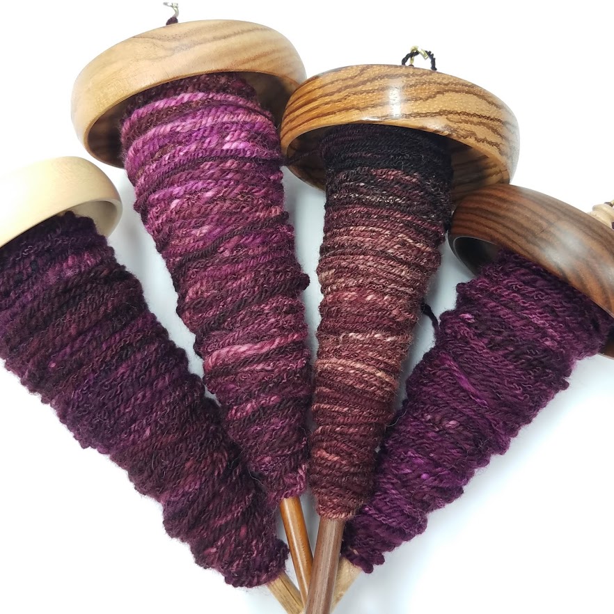 Four supported spindles of singles turned into four drop spindles worth of chain plying